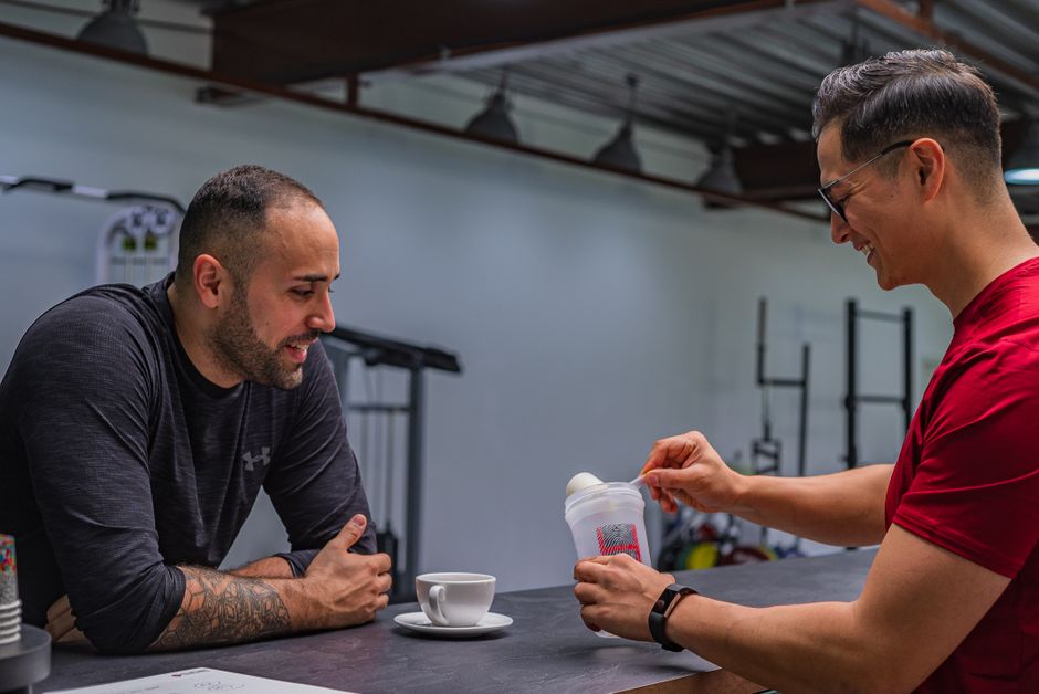 Pre workout vs coffee for gym: side-by-side comparison of a scoop of pre-workout powder and a black coffee cup