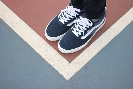 Flat-soled Vans sneakers on a gym floor next to a barbell, showing are vans good for lifting