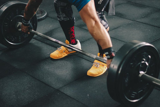 Man wearing the best flat shoes for lifting during a barbell squat in a gym setting