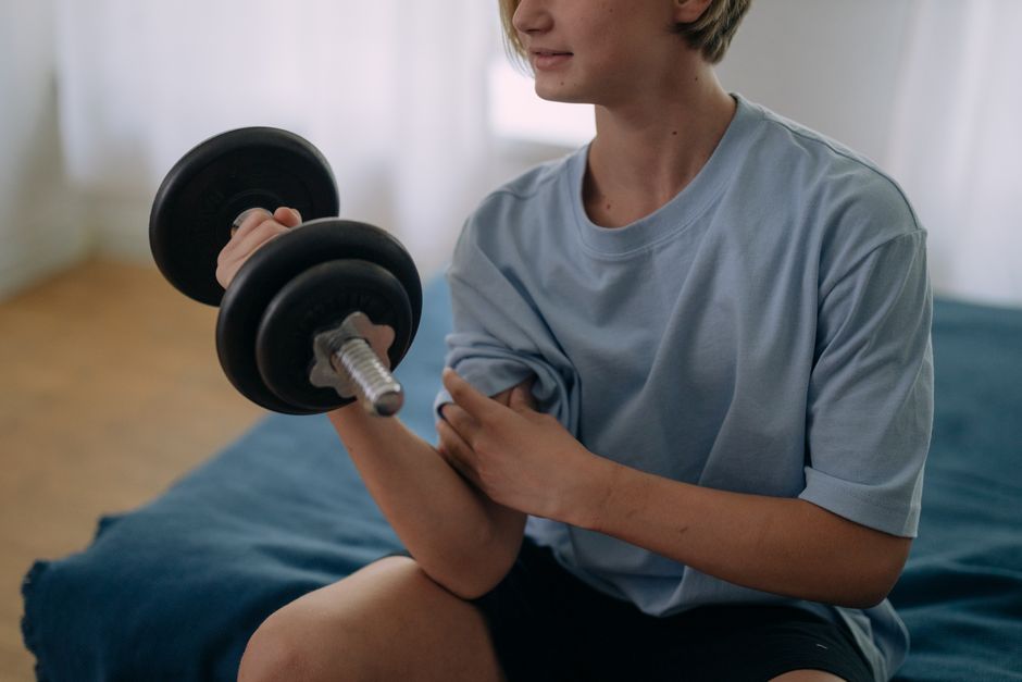 Teen athlete lifting weights in gym, exploring whether is creatine safe for teenagers based on current research